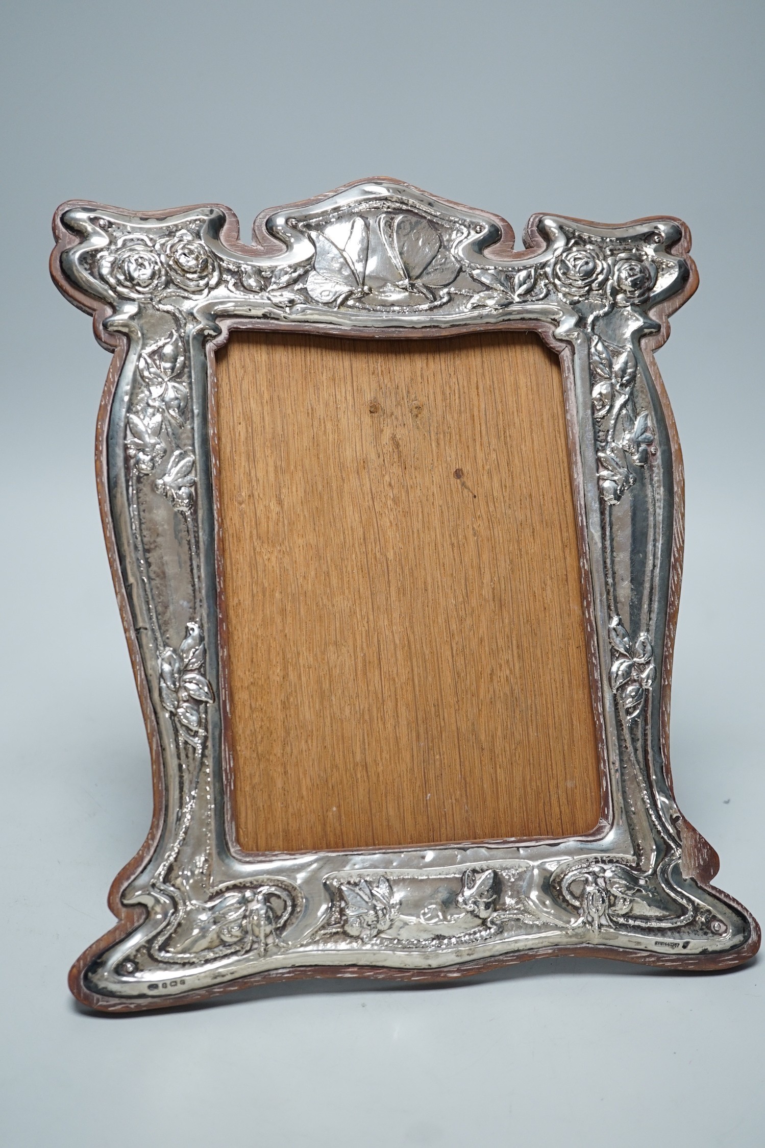 An Edwardian Art Nouveau repousse silver mounted photograph frame, decorated with insects amongst foliage, J. Aitken & Son, Birmingham, 1904, 29.9cm.